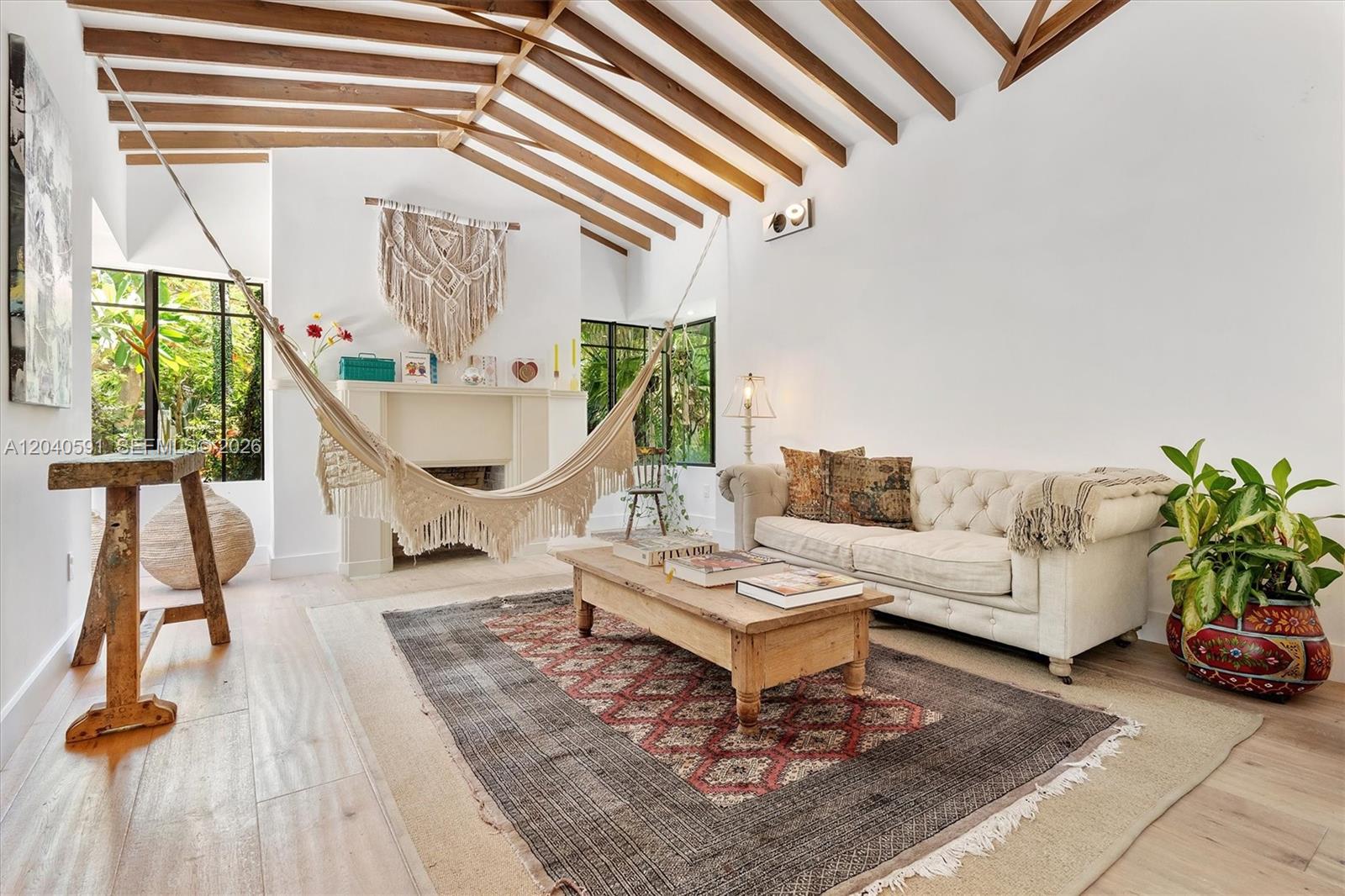 A living room features a vaulted wood-beam ceiling, a hammock, a fireplace, and a sofa — 547 NE 59th St, Miami FL 33137, MIAMI, FL