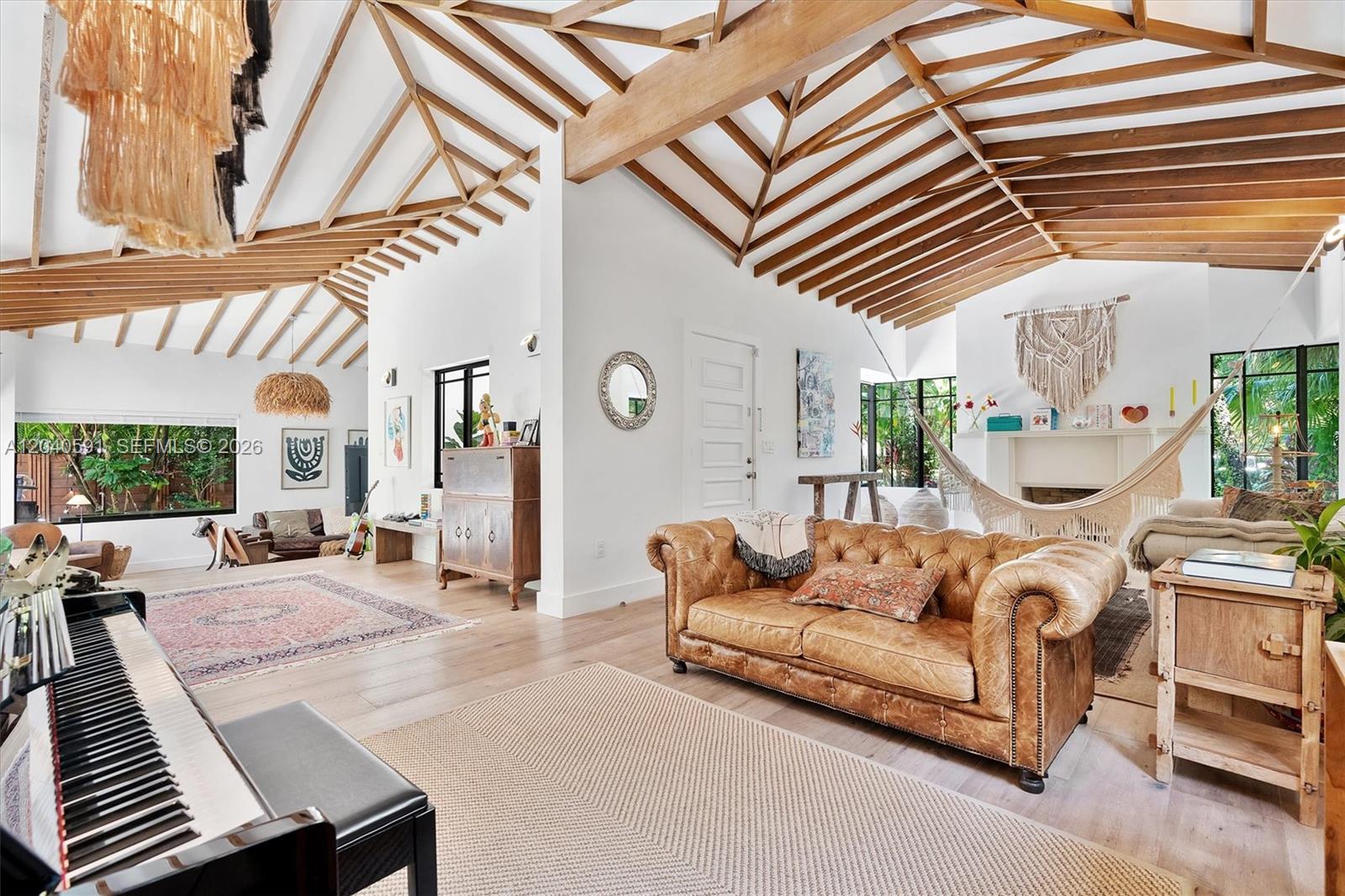 A living room features a vaulted wood-beamed ceiling, a leather sofa, and a hammock — 547 NE 59th St, Miami FL 33137, MIAMI, FL