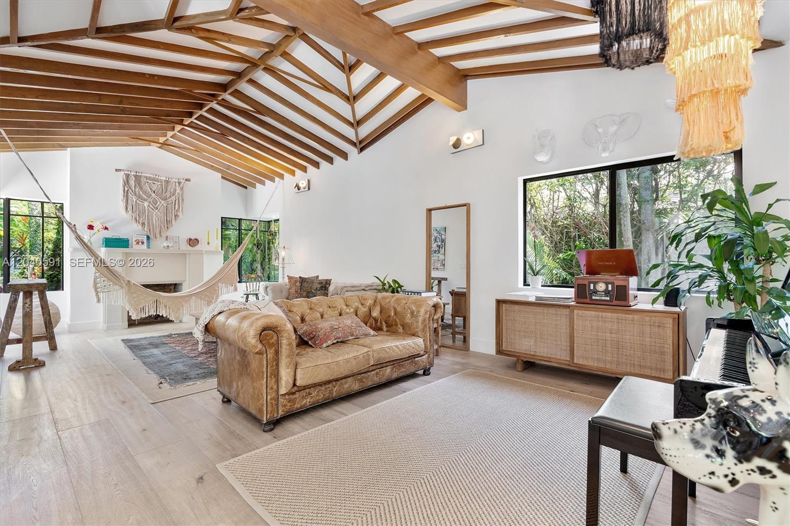 A living room features a vaulted wood-beam ceiling, a leather sofa, and a hanging hammock — 547 NE 59th St, Miami FL 33137, MIAMI, FL
