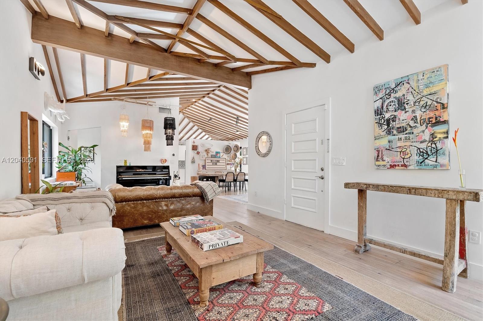 A living room features exposed wooden ceiling beams, a white door, and a wooden console table — 547 NE 59th St, Miami FL 33137, MIAMI, FL