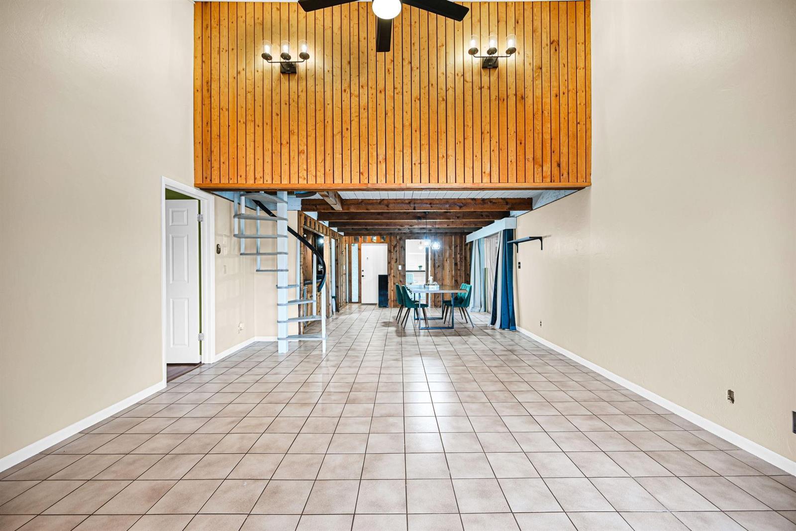 A large room features tile flooring, a wood-paneled wall, and a spiral staircase — 3465 Spring Bluff Place # 18, Lauderhill FL 33319, LAUDERHILL, FL