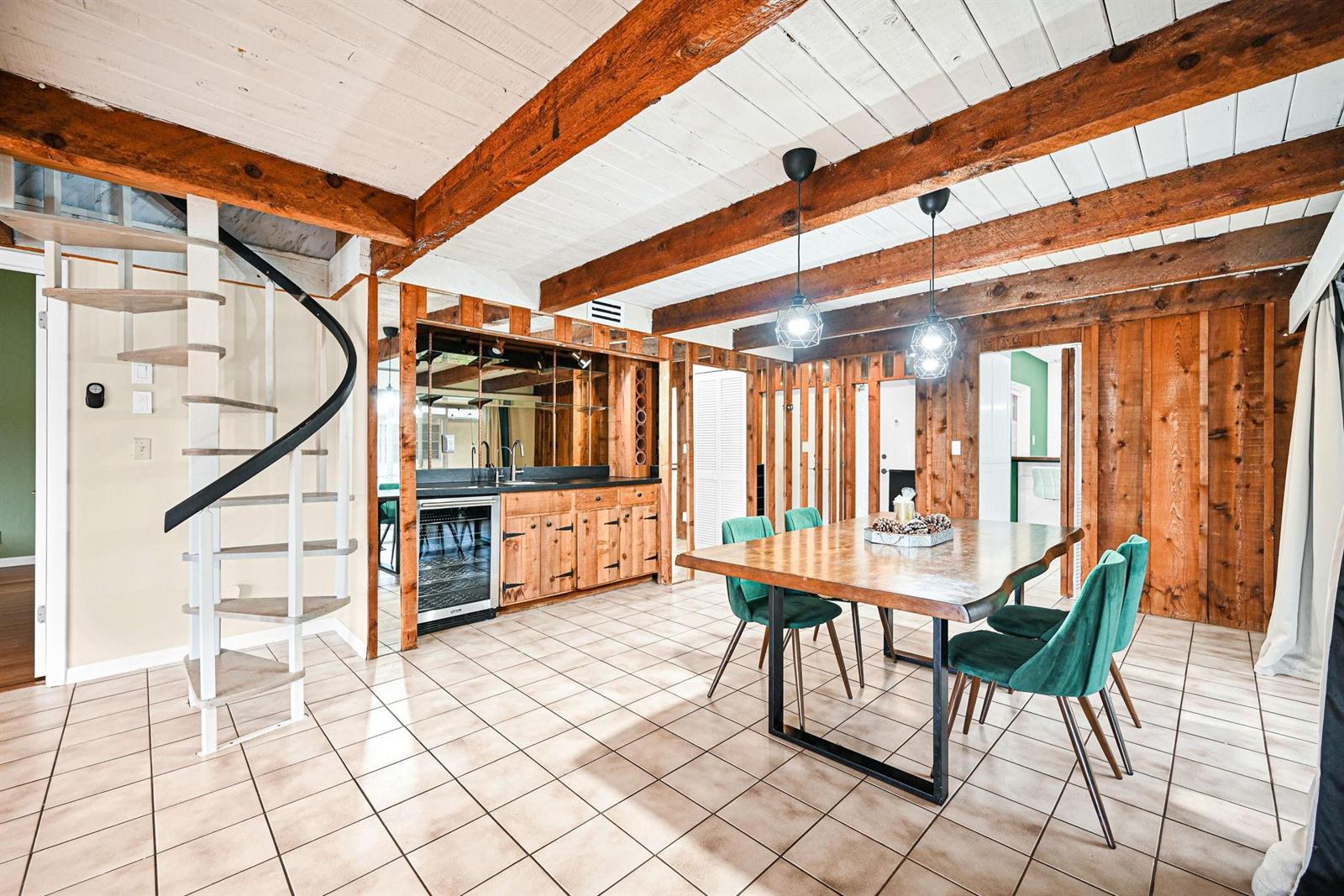 A dining room features a wooden table, green chairs, a spiral staircase, and wood-paneled walls — 3465 Spring Bluff Place # 18, Lauderhill FL 33319, LAUDERHILL, FL