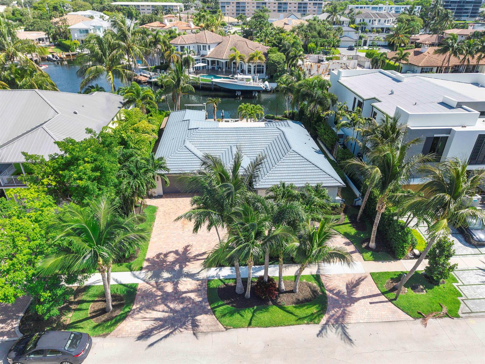 An aerial view shows a single-story house with a grey roof, palm trees, and driveway — 725 NE 36th Street, Boca Raton FL 33431, BOCA RATON, FL