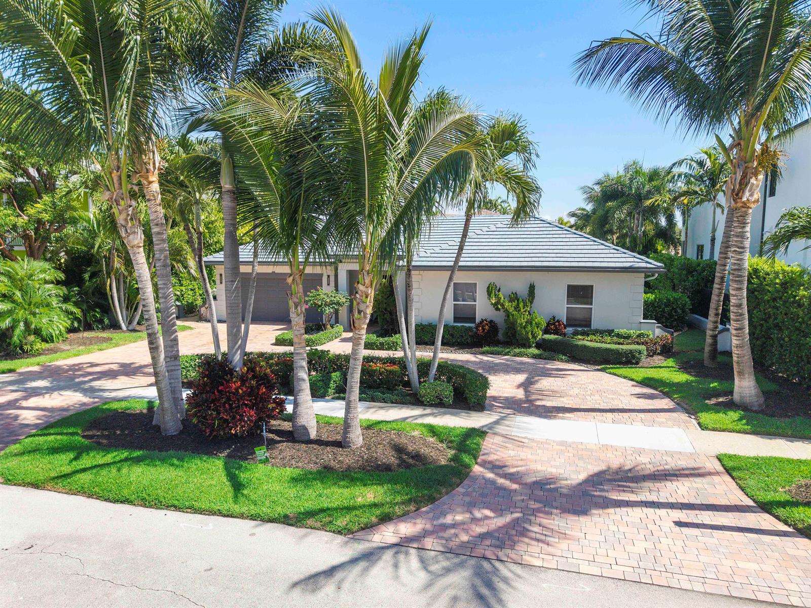 A single-story house with a tiled roof and a brick driveway surrounded by palm trees — 725 NE 36th Street, Boca Raton FL 33431, BOCA RATON, FL