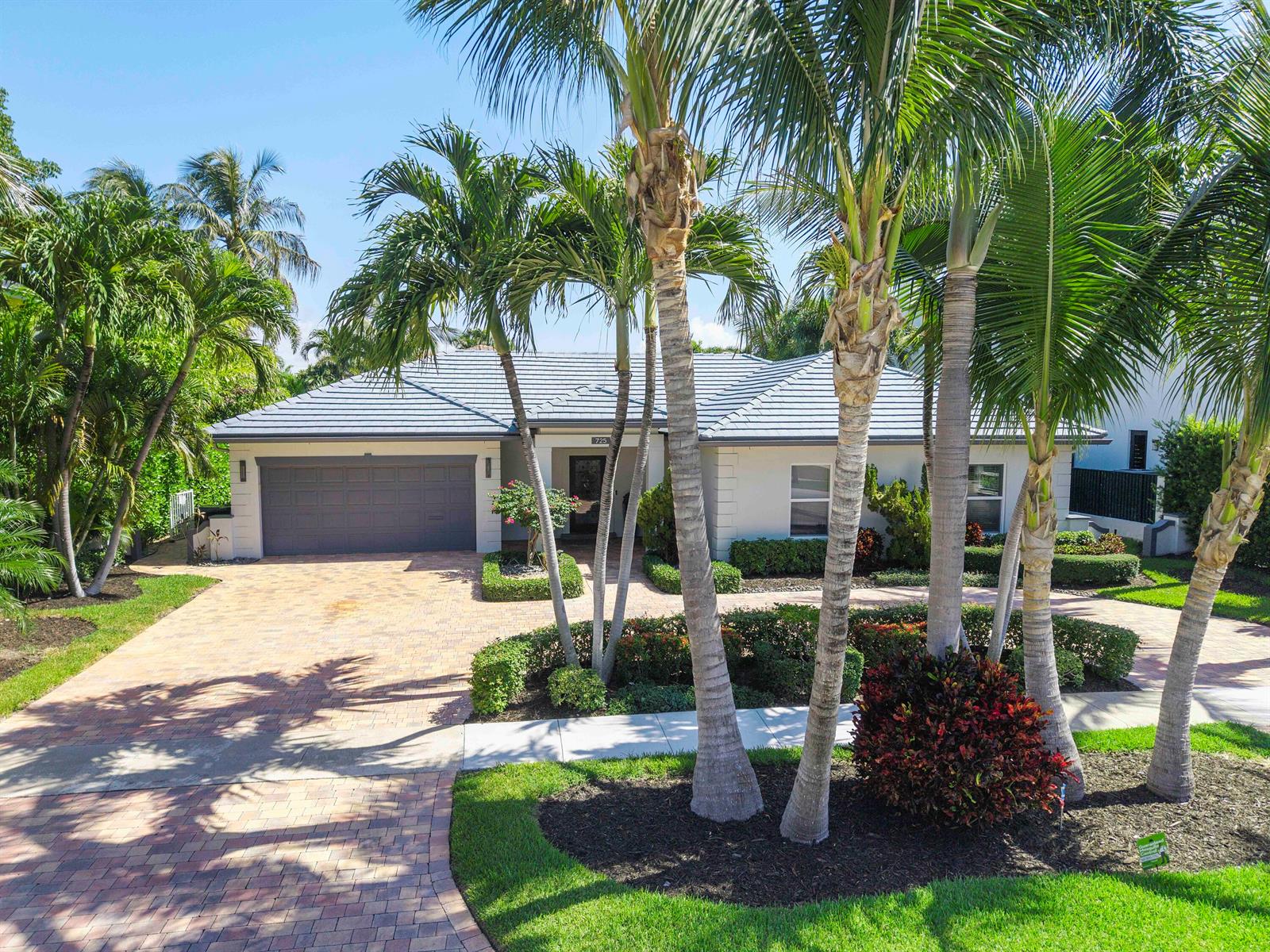 A single-story house with a gray tiled roof, a paved driveway, and several palm trees — 725 NE 36th Street, Boca Raton FL 33431, BOCA RATON, FL