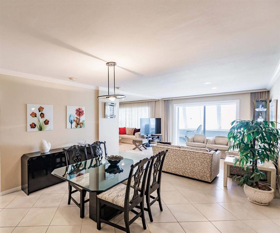 A dining area with a glass table and chairs opens into a living room — 1055 W PEPPERTREE DRIVE UNIT 802AA, SARASOTA, FL