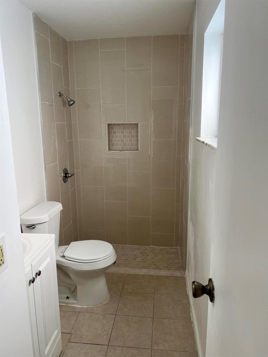 A bathroom features a tiled walk-in shower, a toilet, and a white vanity — 11421 NW 39th Place, Sunrise FL 33323, SUNRISE, FL