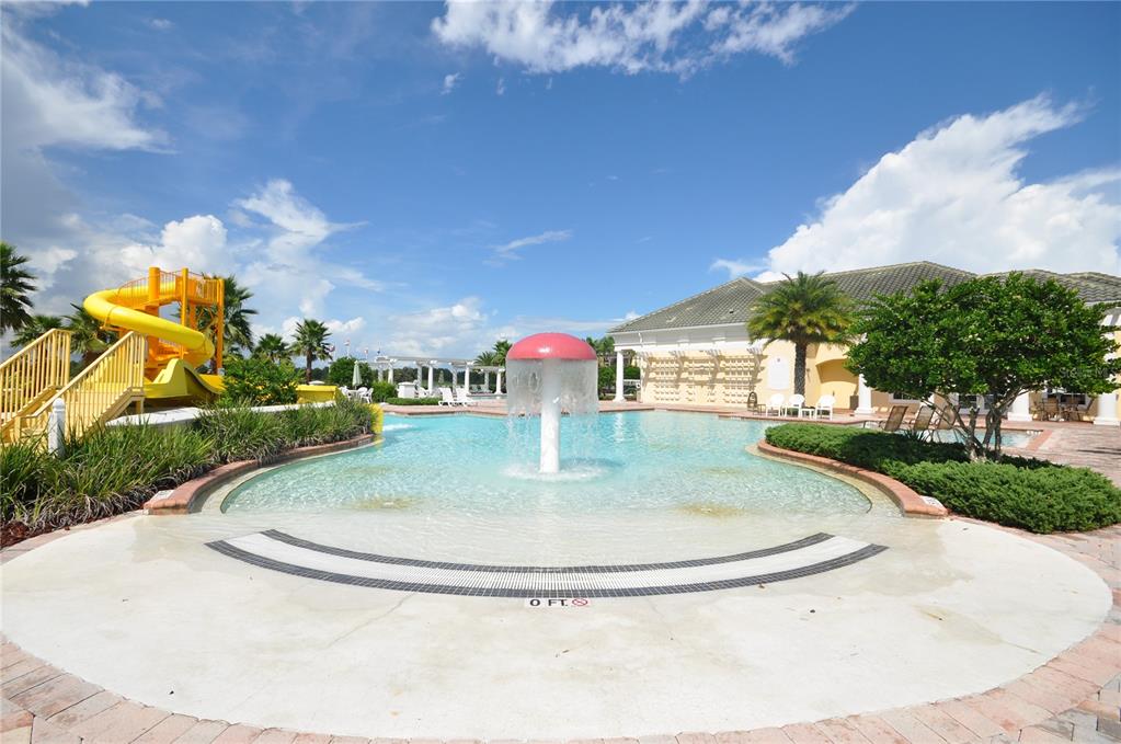 A swimming pool features a mushroom-shaped water fountain and a yellow slide — 5558 LEWISHAM DRIVE, DAVENPORT, FL