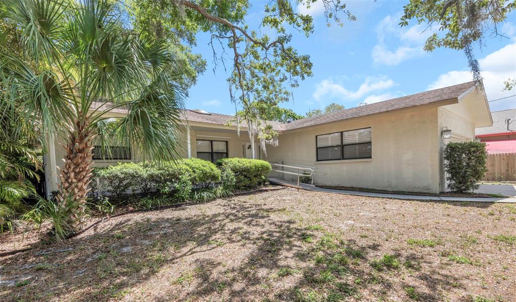 A single-story house with a wheelchair ramp leading to the front entrance and a palm tree — 753 SEMINOLE BOULEVARD, TARPON SPRINGS, FL