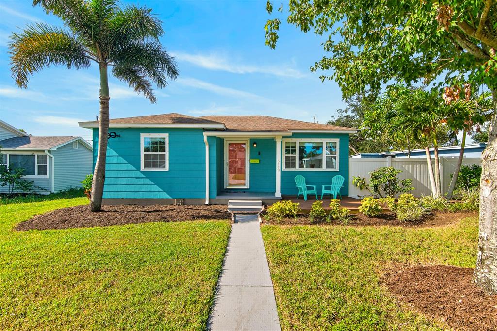 A teal single-story house features a palm tree, a front walkway, and two turquoise chairs — 5119 29TH AVENUE N, ST PETERSBURG, FL
