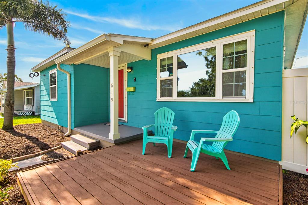 A teal house exterior features a wooden deck with two light blue Adirondack chairs — 5119 29TH AVENUE N, ST PETERSBURG, FL