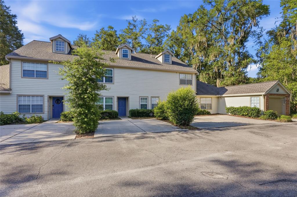 A two-story townhouse with light siding, blue front doors, and an attached garage — 5258 SW 97TH DRIVE, GAINESVILLE, FL