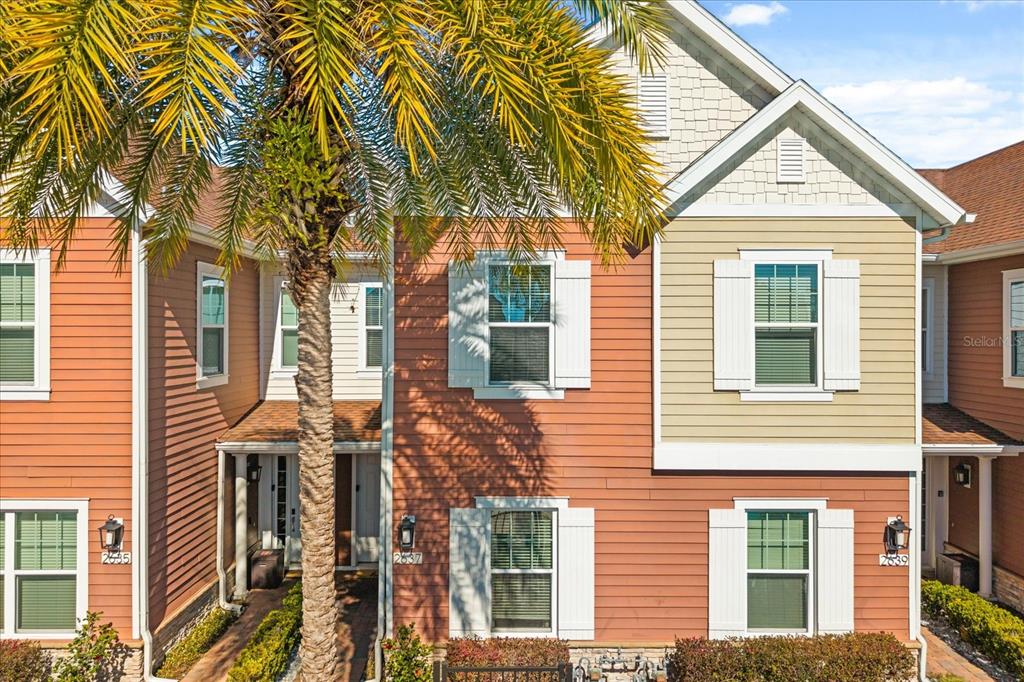 An exterior view of a multi-story residential building with a palm tree in the foreground — 2637 SUNRISE SHORES DRIVE, KISSIMMEE, FL