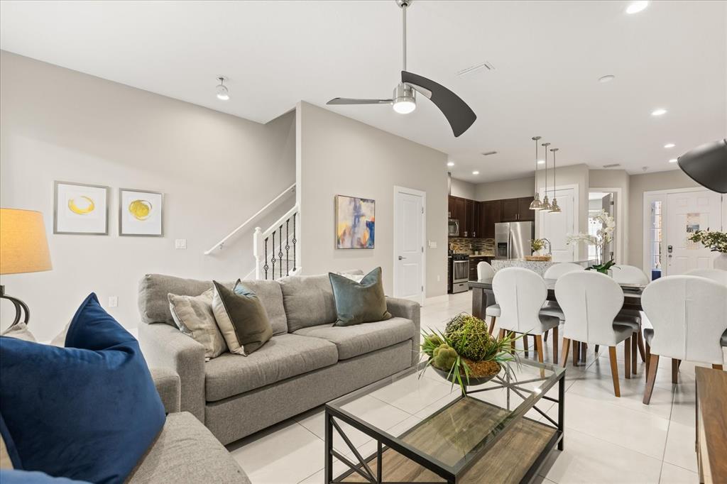 A kitchen with dark wood cabinets, granite countertops, and a breakfast bar with four stools — 2637 SUNRISE SHORES DRIVE, KISSIMMEE, FL