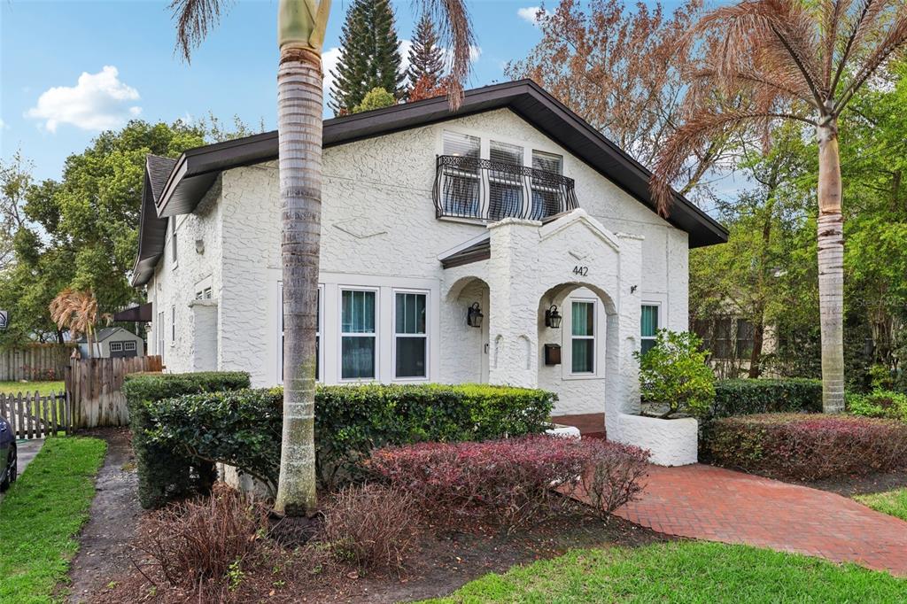A two-story white stucco house features a brick walkway, arched entryway, and a small balcony — 442 BRIERCLIFF DRIVE, ORLANDO, FL