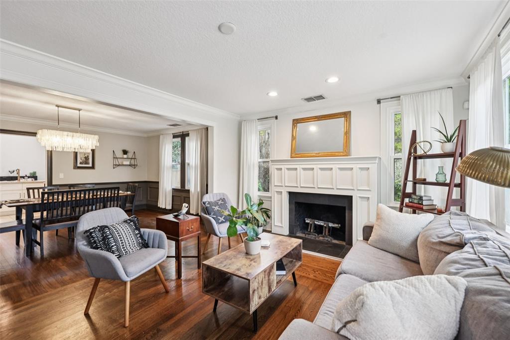 A living room with a fireplace, hardwood floors, and an adjacent dining area — 442 BRIERCLIFF DRIVE, ORLANDO, FL