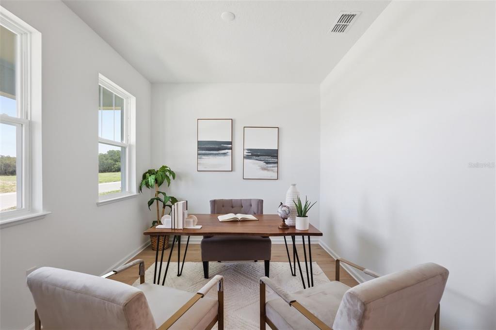 A home office features a wooden desk, three chairs, and two framed wall art pieces — 1595 STONECLIFFF DRIVE, APOPKA, FL