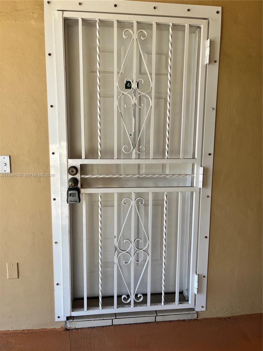 A white metal security screen door is mounted over a residential entrance — 6780 W 2nd Ct # 408, Hialeah FL 33012, HIALEAH, FL