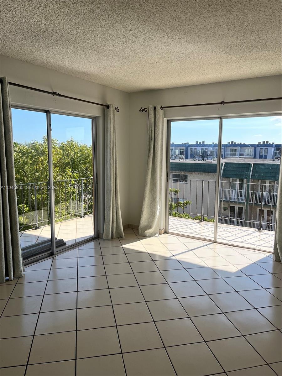 A white stacked washer and dryer unit stands next to a water heater — 6780 W 2nd Ct # 408, Hialeah FL 33012, HIALEAH, FL