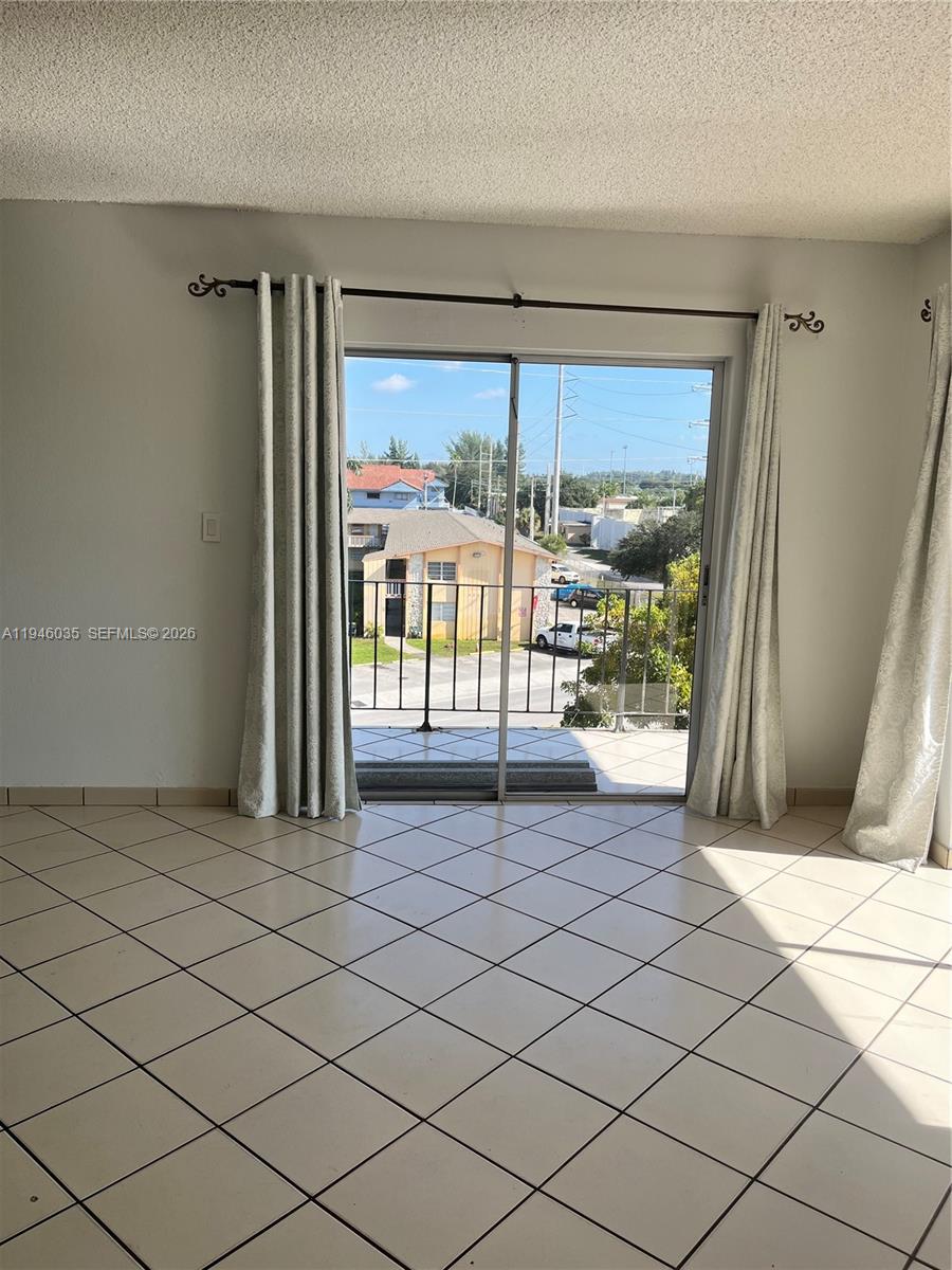 A bedroom features a gray upholstered bed, light wood-look flooring, and a ceiling light fixture — 6780 W 2nd Ct # 408, Hialeah FL 33012, HIALEAH, FL