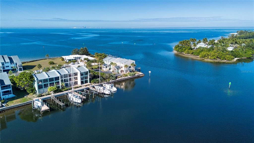 An aerial view of waterfront condominiums with boat slips along a calm bay — 907 BAHIA DEL SOL DRIVE UNIT 907, RUSKIN, FL
