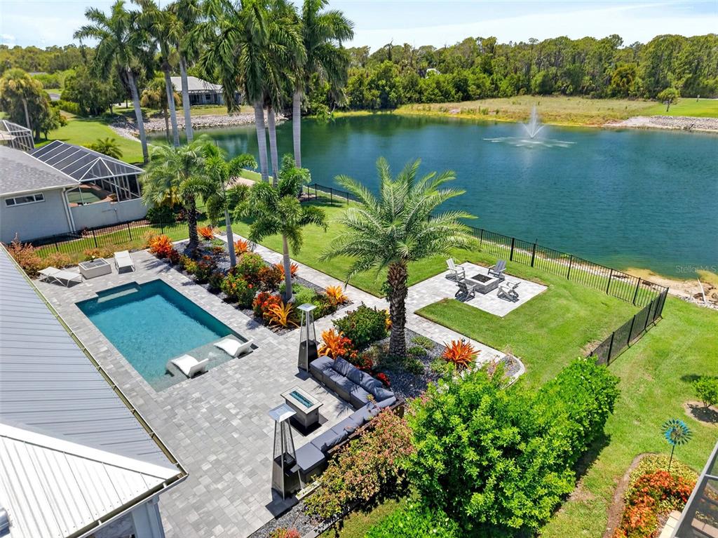 An aerial view of a backyard featuring a swimming pool, patio, fire pit, and pond — 28116 N MCCALL ROAD, ENGLEWOOD, FL