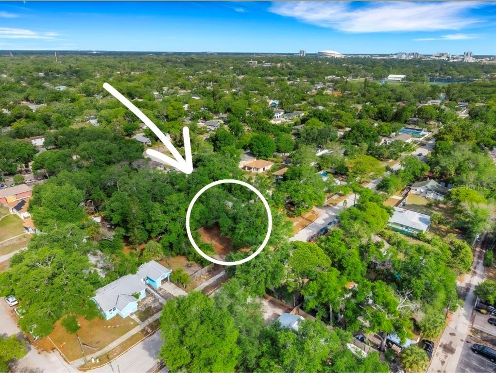 An aerial view shows a vacant, tree-covered residential lot surrounded by houses and streets — 2715 5TH STREET S, ST PETERSBURG, FL