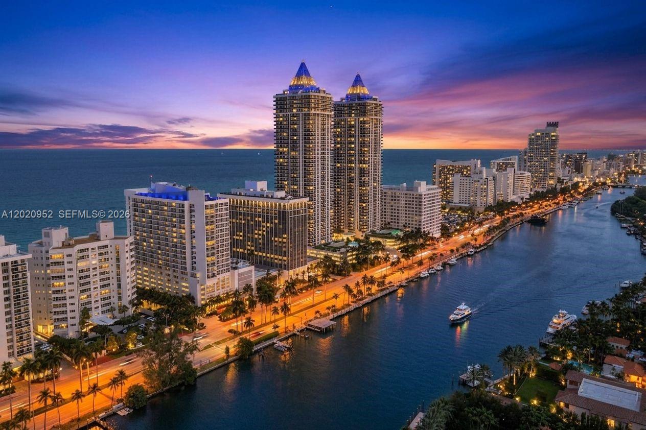 An aerial view shows high-rise buildings along a waterway at sunset — 4925 Collins Ave # 3H, Miami Beach FL 33140, MIAMI BEACH, FL