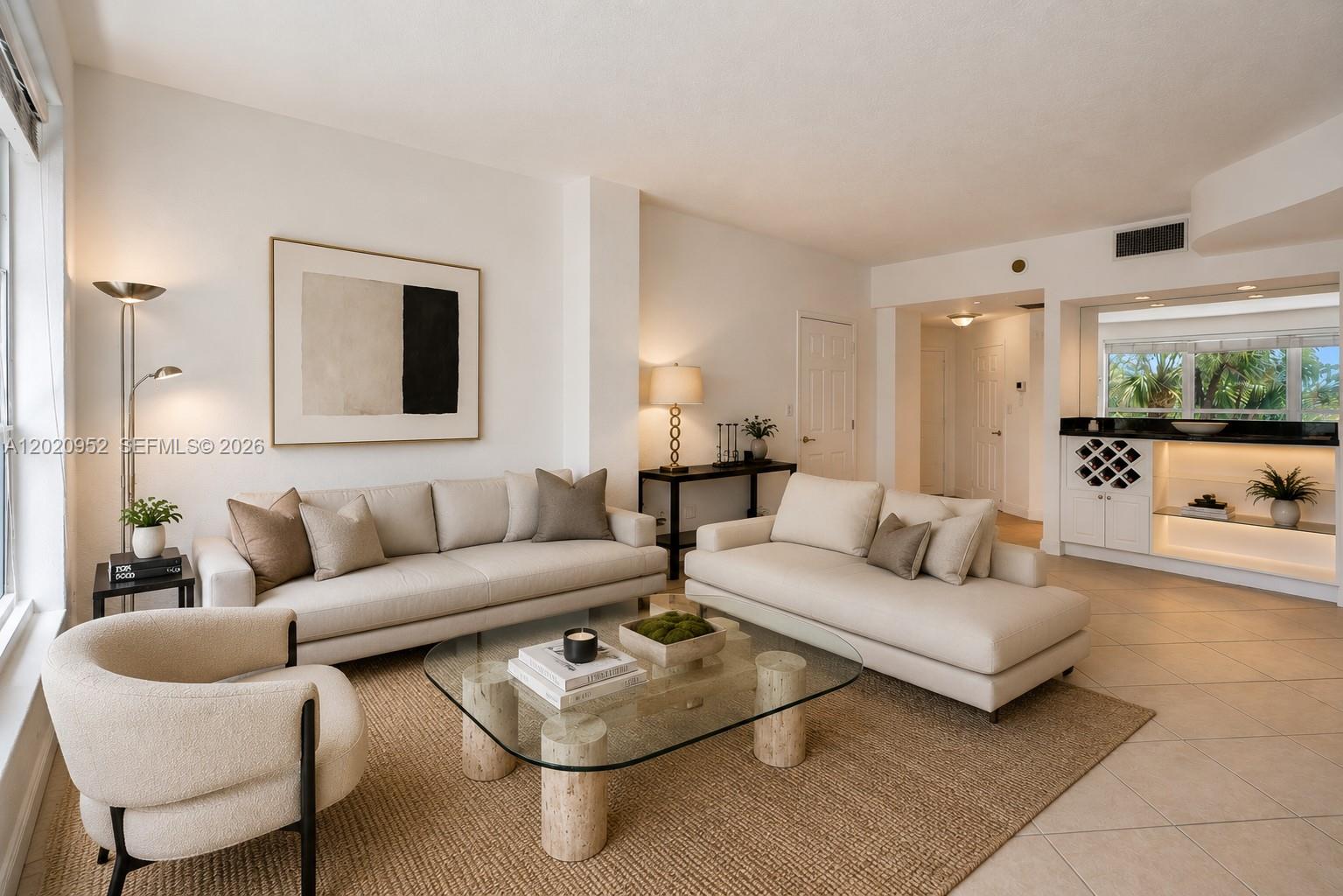 A living room features two beige sofas, a glass coffee table, and a built-in bar — 4925 Collins Ave # 3H, Miami Beach FL 33140, MIAMI BEACH, FL