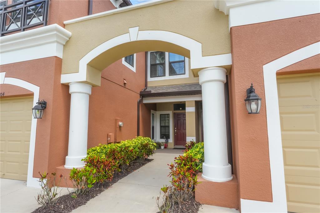 A screened-in patio features blue and white floor tiles, a screen door, and water views — 9204 FOX SPARROW ROAD, TAMPA, FL