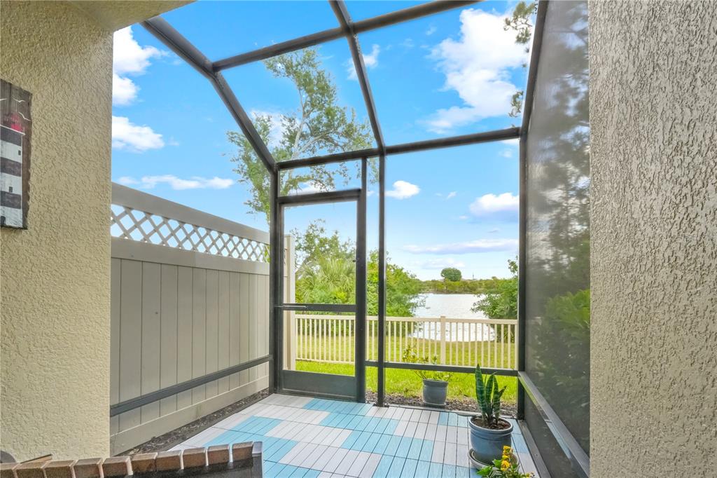 A covered entryway features a red front door, a bay window, and potted plants — 9204 FOX SPARROW ROAD, TAMPA, FL