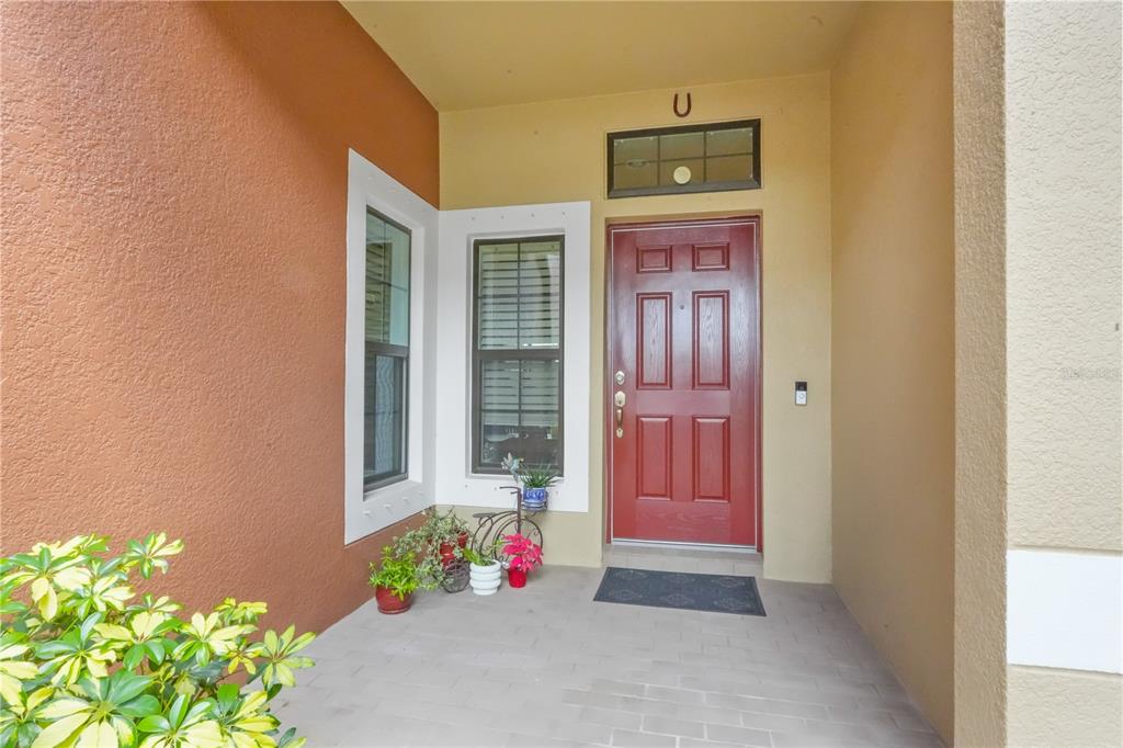 A screened-in patio features blue and white interlocking floor tiles and a view of water — 9204 FOX SPARROW ROAD, TAMPA, FL