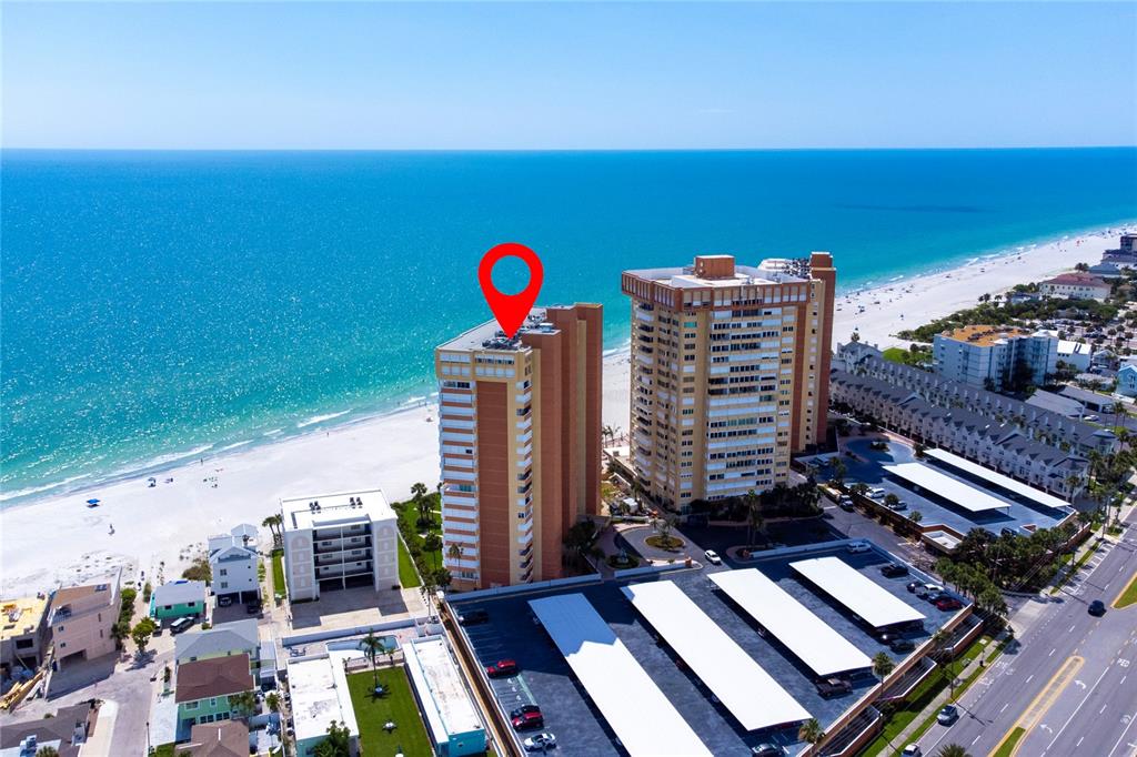 An aerial view shows two tall beachfront condominium buildings with parking lots and the ocean — 17900 GULF BOULEVARD UNIT 11C, REDINGTON SHORES, FL