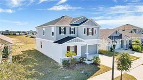 A two-story suburban house with gray siding and a dark shingled roof — 911 ALVANLEY COURT, DAVENPORT, FL