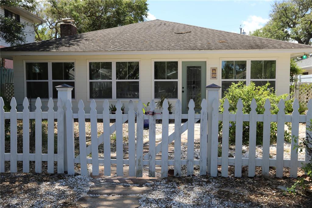 A single-story house with a white picket fence and a stone walkway in the front — 825 E 23RD AVENUE, NEW SMYRNA BEACH, FL