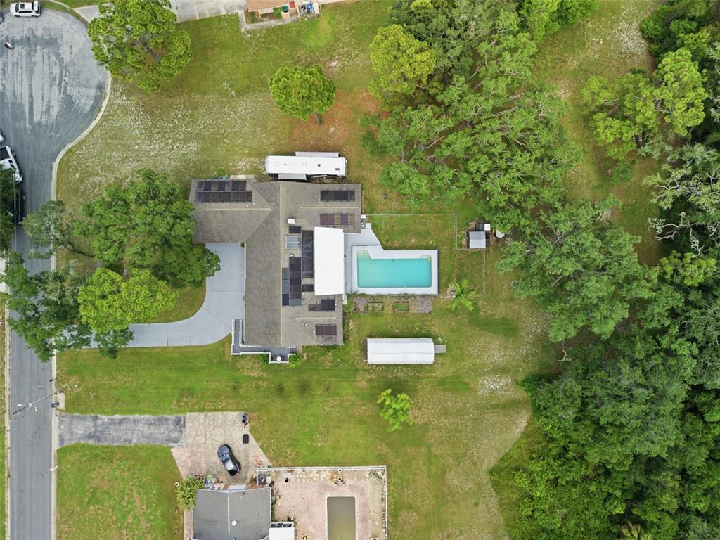 An aerial view shows a house with a pool, solar panels, and a large yard — 6706 WALDORF COURT, NEW PORT RICHEY, FL