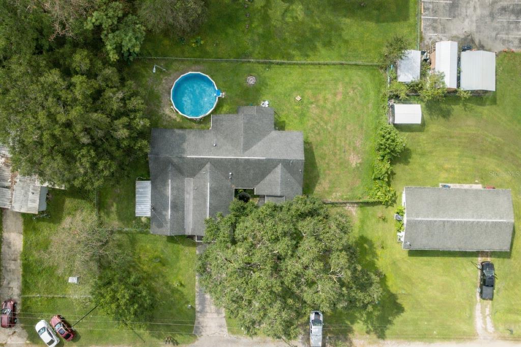 An aerial view shows a house with a pool, large trees, and multiple outbuildings — 18160 SPANGLER AVENUE, BROOKSVILLE, FL