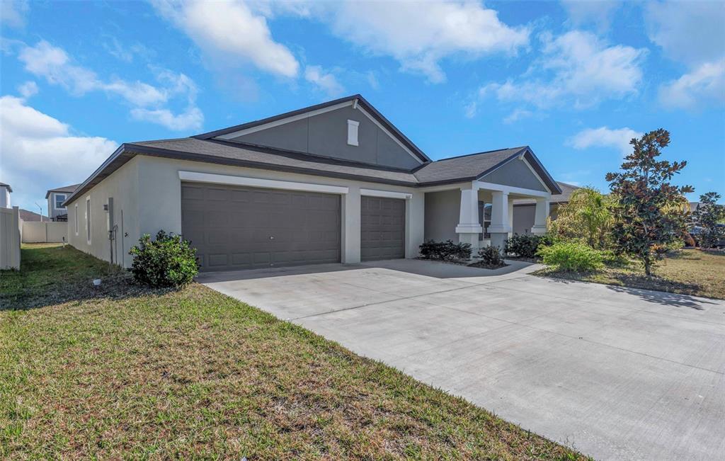 A single-story house with a two-car garage, a covered entryway, and a concrete driveway — 16612 CARLTON POND STREET, WIMAUMA, FL