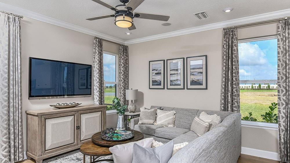 A living room features a sectional sofa, a television on a console, and large windows — 10836 ECLIPSE STREET, SARASOTA, FL