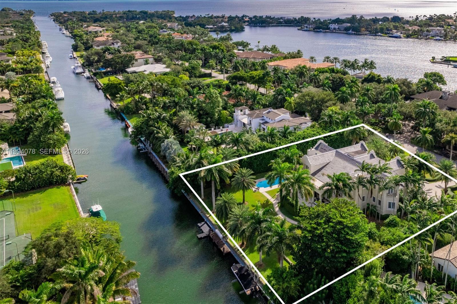 An aerial view shows a large waterfront estate with a pool and lush landscaping — 585 Arvida Pkwy, Coral Gables FL 33156, CORAL GABLES, FL