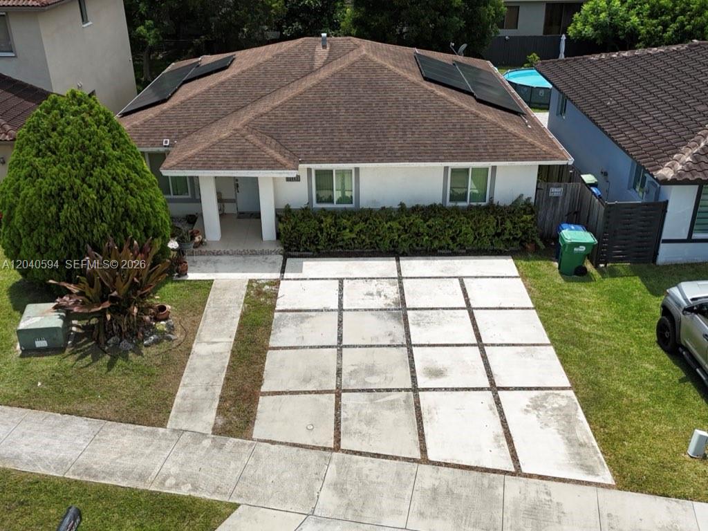 An aerial view of a single-story house with a paved driveway and solar panels — 22442 SW 109th Ct, Miami FL 33170, MIAMI, FL