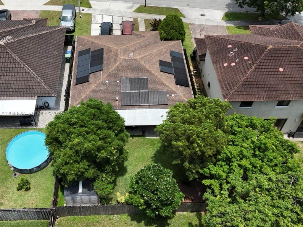 An aerial view shows a house with solar panels, a backyard pool, and trees — 22442 SW 109th Ct, Miami FL 33170, MIAMI, FL