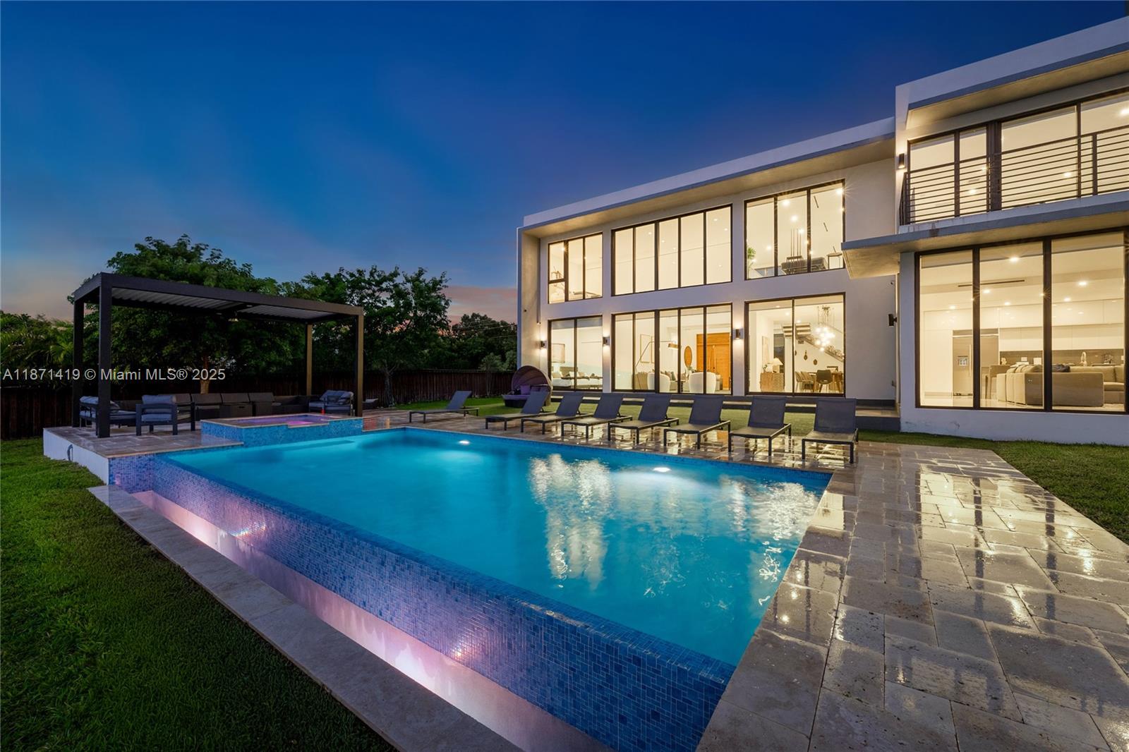 A modern two-story house with a pool, patio, and lounge chairs at twilight — 5420 SW 72nd Ave, Miami FL 33155, MIAMI, FL