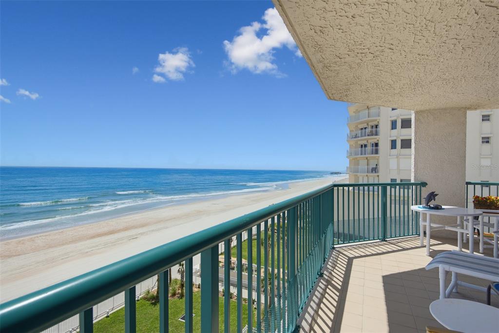 A balcony with a green metal railing overlooks a sandy beach and the ocean — 3315 S ATLANTIC AVENUE UNIT 408, DAYTONA BEACH SHORES, FL