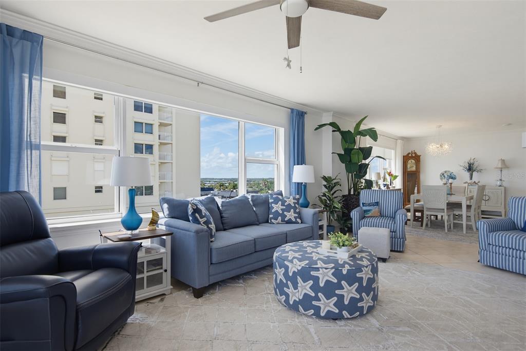 A living room features a blue sofa, a starfish-patterned ottoman, and large windows with views — 3315 S ATLANTIC AVENUE UNIT 408, DAYTONA BEACH SHORES, FL