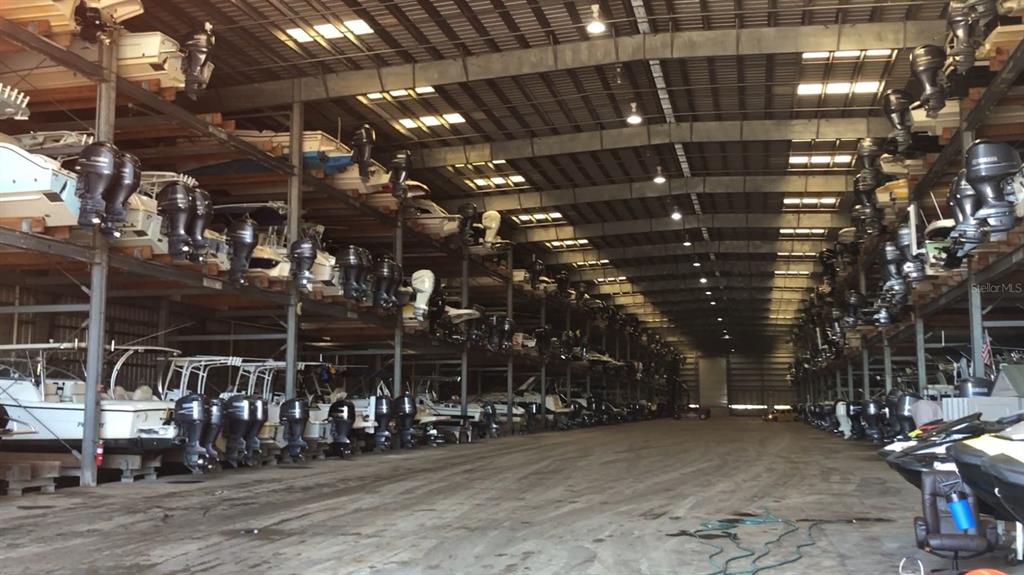 A large indoor boat storage facility with multiple levels of racks holding various watercraft — 1780 PHILLIPPI SHORES DRIVE UNIT D3-39, SARASOTA, FL