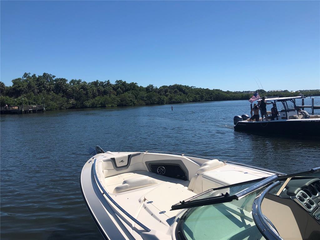 A view from the bow of a boat looking toward another boat and shoreline trees — 1780 PHILLIPPI SHORES DRIVE UNIT D3-39, SARASOTA, FL