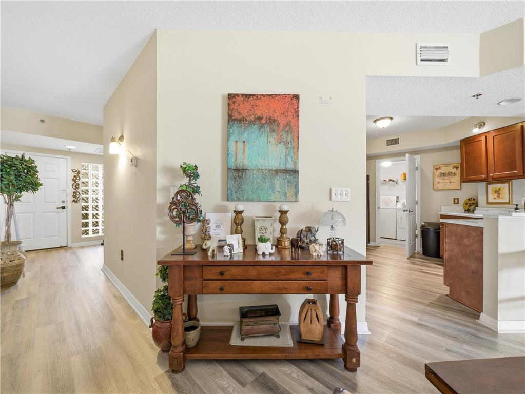 A wooden console table sits in a hallway featuring light wood flooring and neutral walls — 5300 S ATLANTIC AVENUE UNIT 3-302, NEW SMYRNA BEACH, FL
