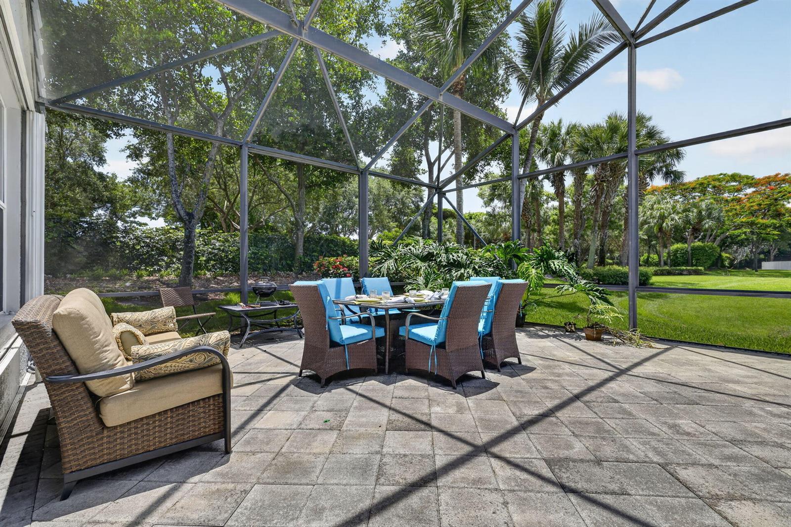 A screened-in patio features a dining set, lounge chairs, and a view of the yard — 6550 Sand City Way, Delray Beach FL 33446, DELRAY BEACH, FL