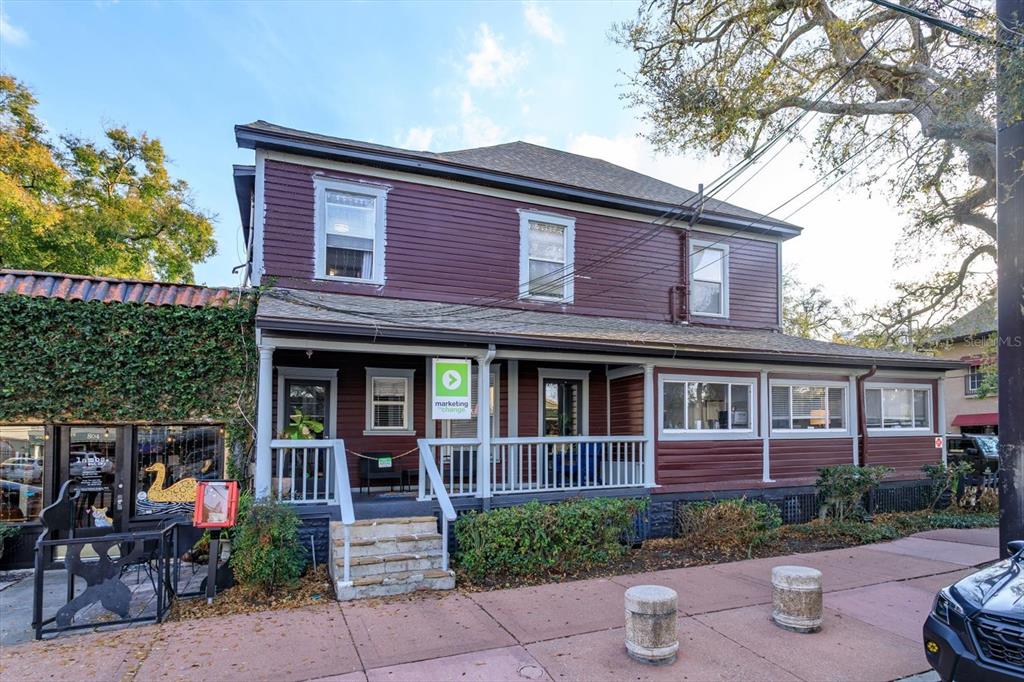 A two-story dark red building with a front porch and a white railing — 37 HILL, ORLANDO, FL